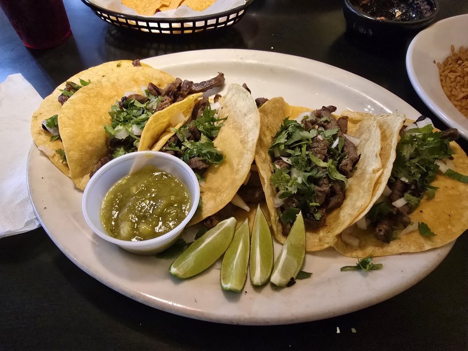 A casual dining table with plated Mexican food.